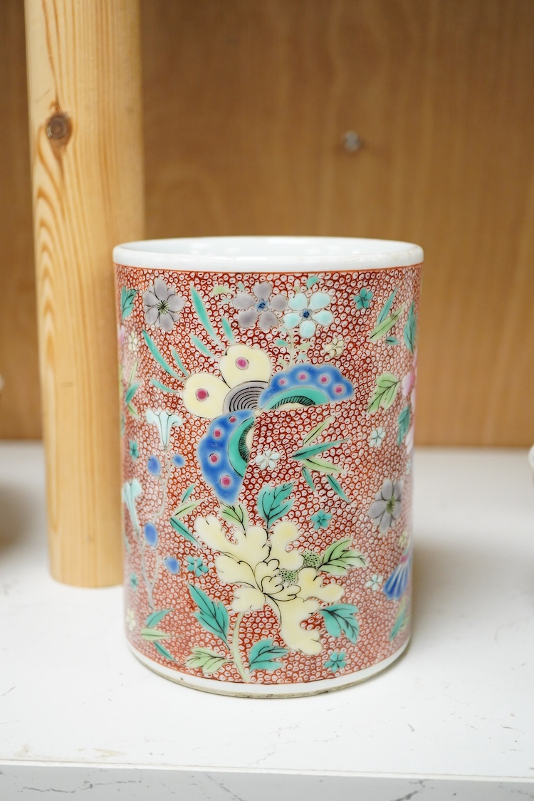 A Chinese famille rose cylindrical brush pot enamelled with butterflies amongst flowers, 14cm high